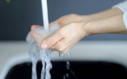 Jeune femme qui se lave les mains avec l'eau adoucie de son robinet