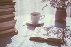 Bureau avec café plante et pile de livres