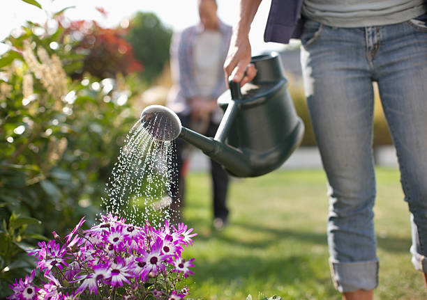 Jeune femme en train d'arroser ses fleurs