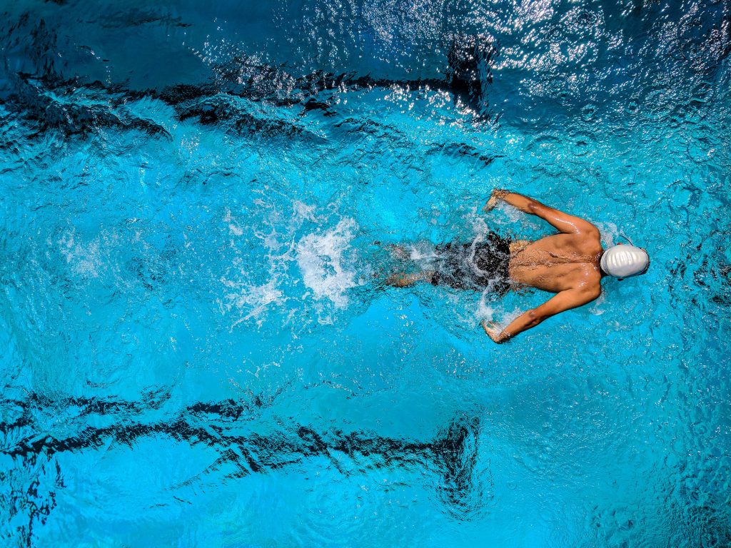 Homme qui pratique la nage sportive dans sa piscine