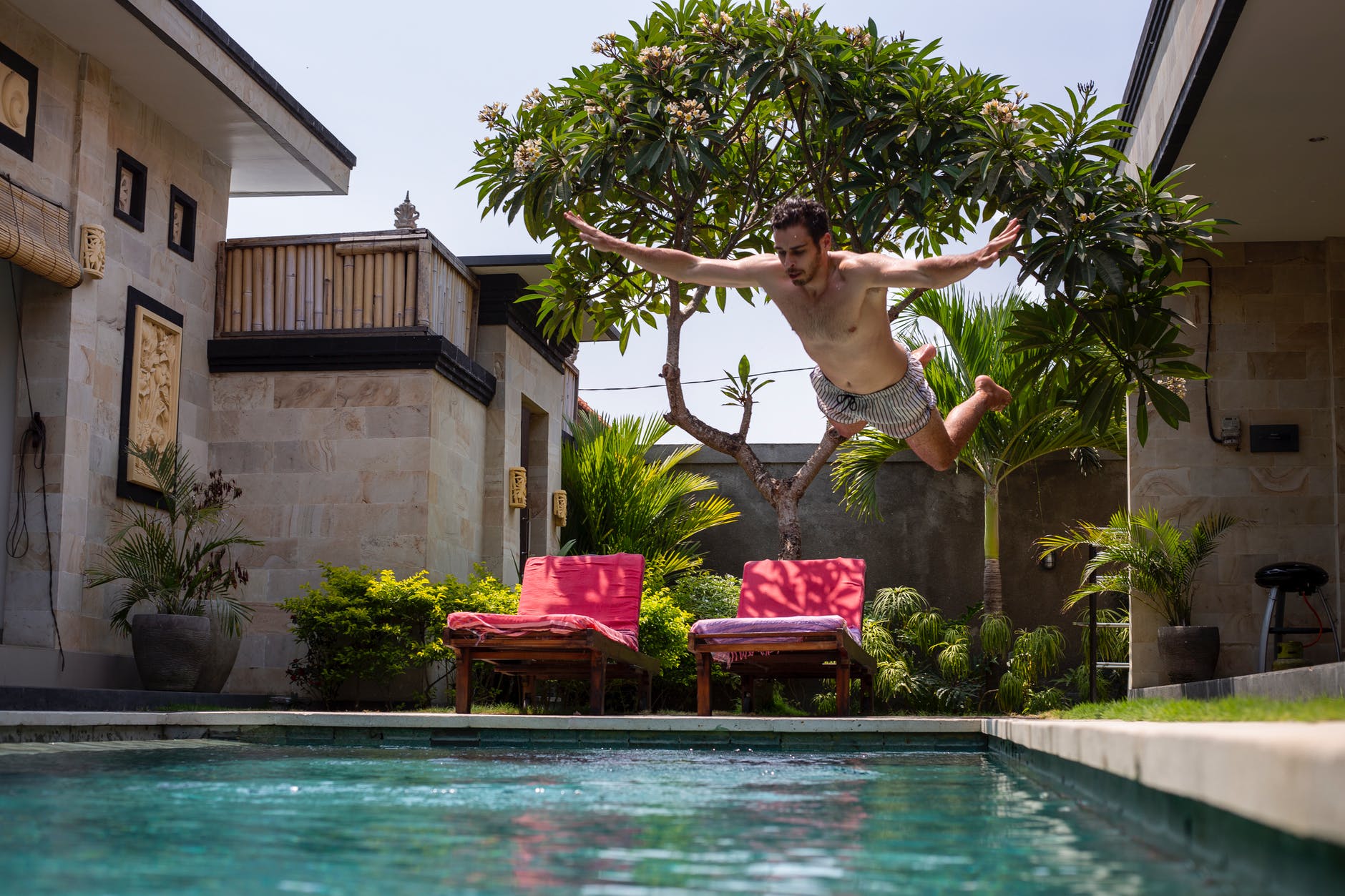 Homme qui fait un plongeon dans sa piscine tout confort